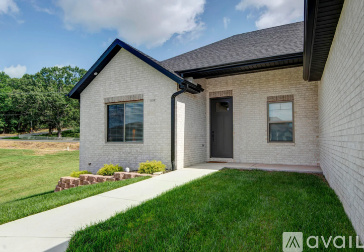 A house with a brick exterior and a black door is for sale.