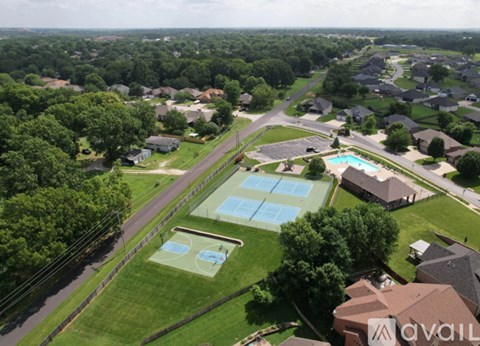 A bird's eye view of a neighborhood with a swimming pool and tennis court.
