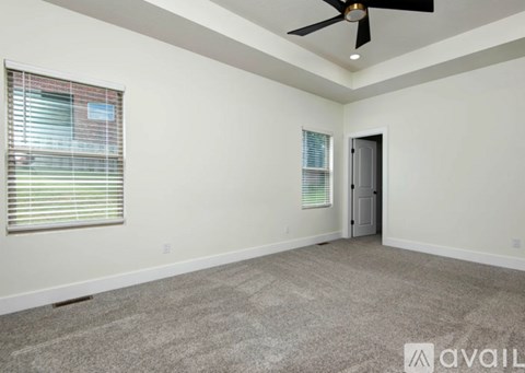 A spacious room with a ceiling fan and carpeted floor.