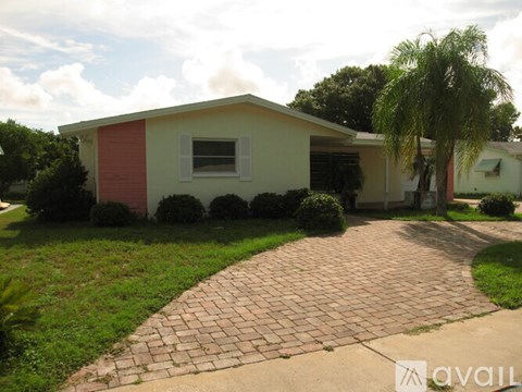 A house with a red and white exterior and a brick walkway in front.