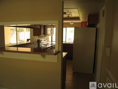A kitchen with a refrigerator and a window.