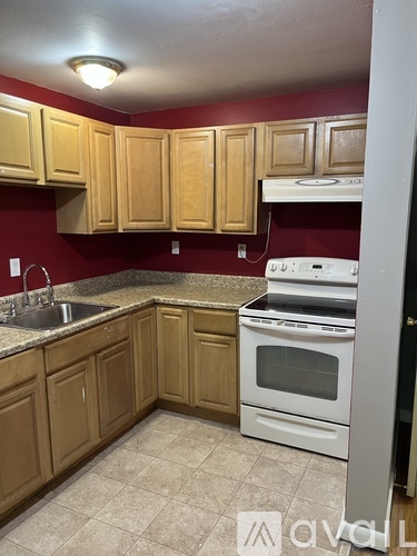 A kitchen with wooden cabinets and a white oven.