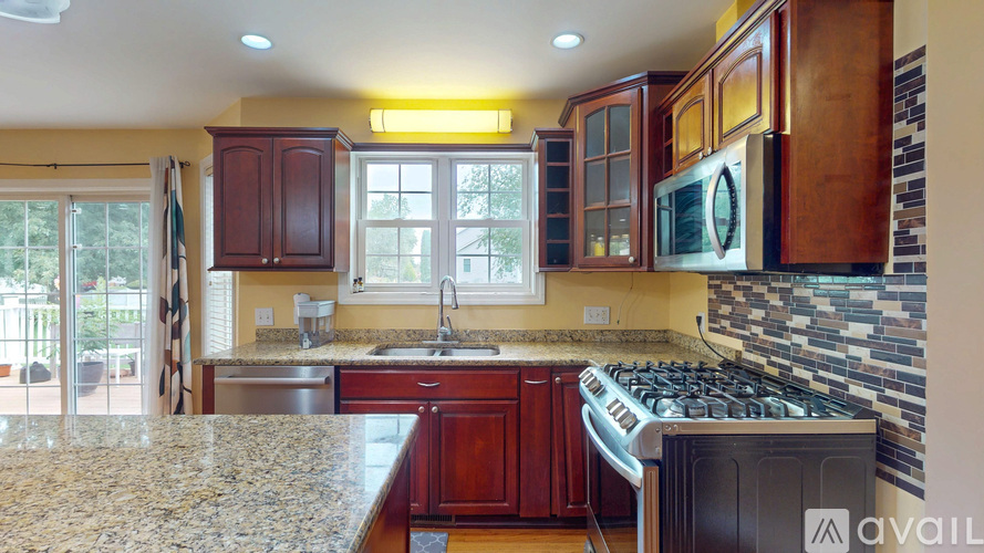A kitchen with granite countertops and wooden cabinets.