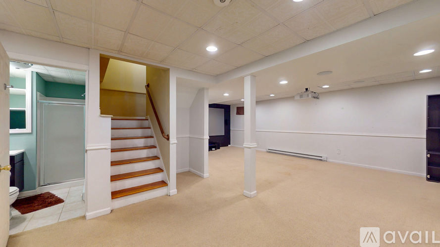 A spacious room with a staircase and a carpeted floor.