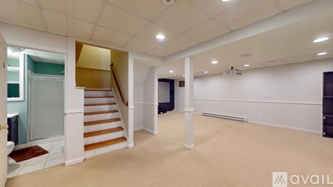 A spacious room with a staircase and a carpeted floor.