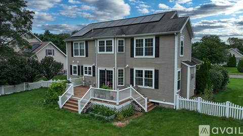 A house with a grey exterior and a white picket fence.