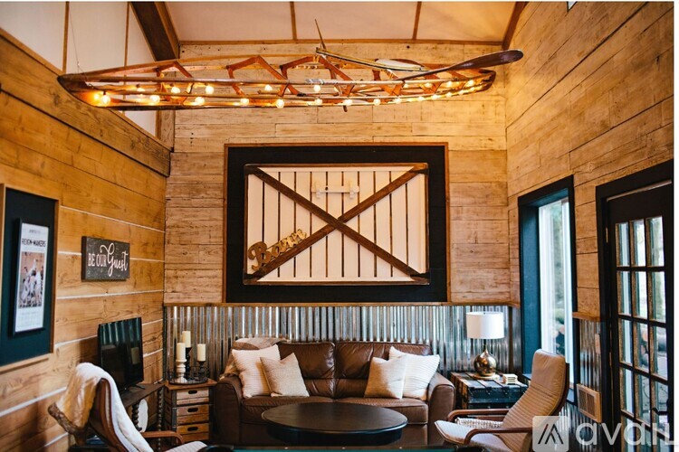 A living room with a brown couch and a wooden wall.
