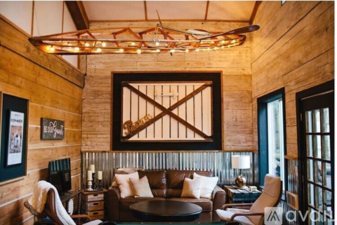 A living room with a brown couch and a wooden wall.