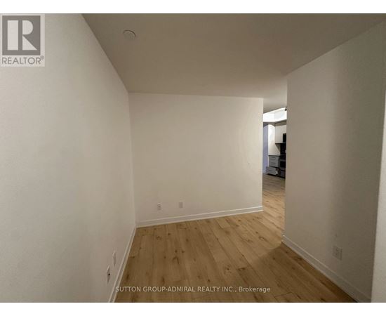 A room with wooden flooring and white walls.