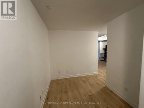 A room with wooden flooring and white walls.
