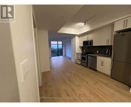 A kitchen with white cabinets and a stainless steel refrigerator.