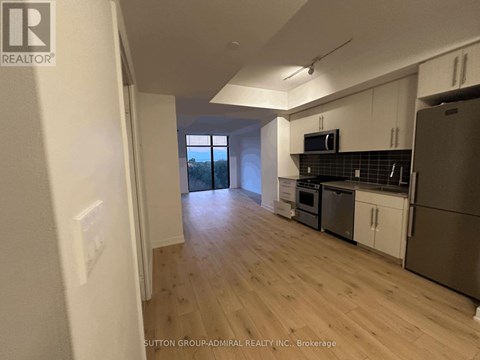 A kitchen with white cabinets and a stainless steel refrigerator.