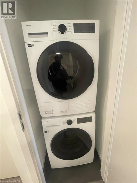 A realtor is standing in front of a washing machine.