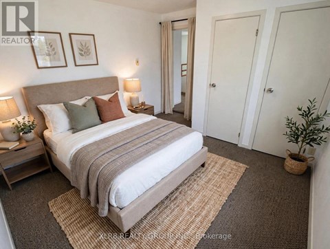 A bedroom with a large bed and a carpeted floor.