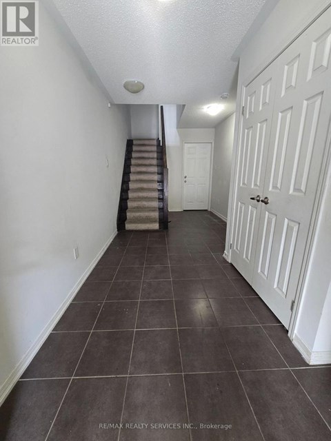 A hallway with a staircase and white doors.