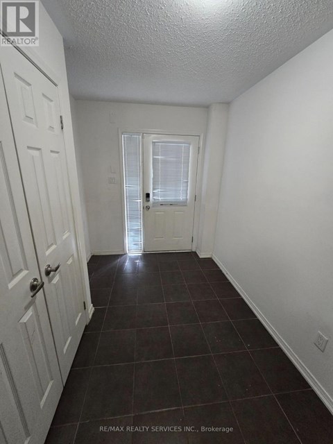 A hallway with a white door and a white wall.