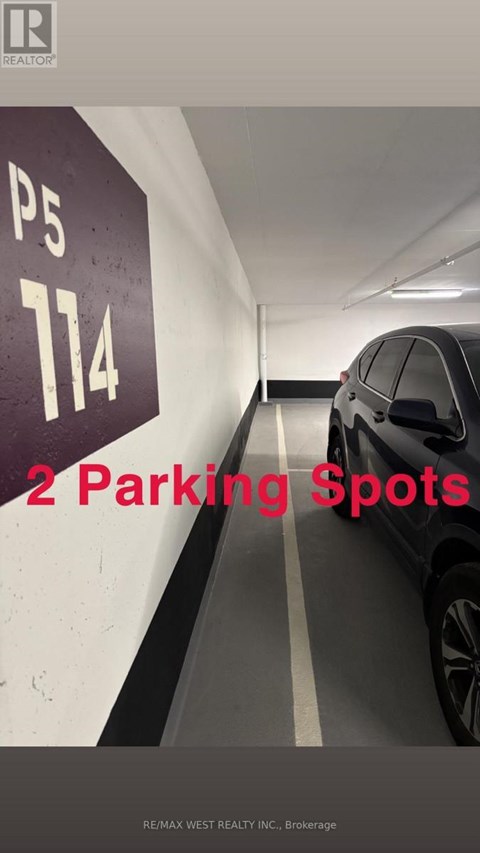 A car is parked in a parking garage with a sign that says "2 Parking Spots".