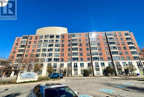A large multi-story building with a parking lot in front.