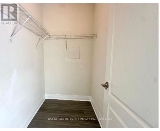 A white wall with a door and a shelf.