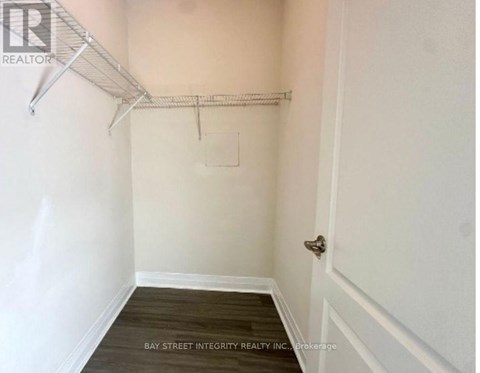 A white wall with a door and a shelf.