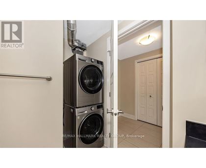A realtor photo of a room with a washer and dryer stacked on top of each other.