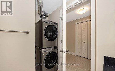 A realtor photo of a room with a washer and dryer stacked on top of each other.