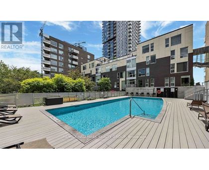 A pool in a backyard surrounded by wooden decking.