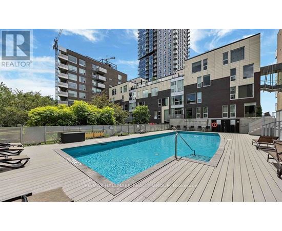 A pool in a backyard surrounded by wooden decking.