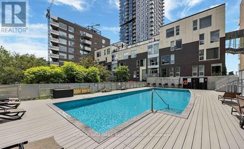 A pool in a backyard surrounded by wooden decking.
