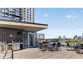 A balcony with a table and chairs overlooks a cityscape.