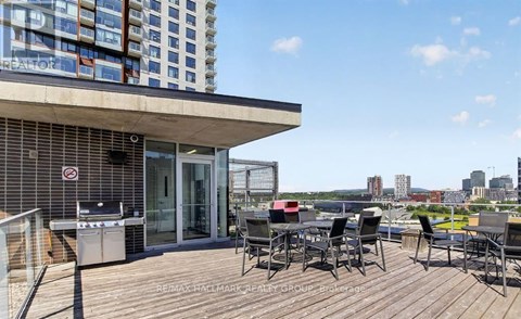 A balcony with a table and chairs overlooks a cityscape.