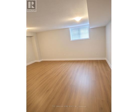 A room with wooden flooring and a window with blinds.