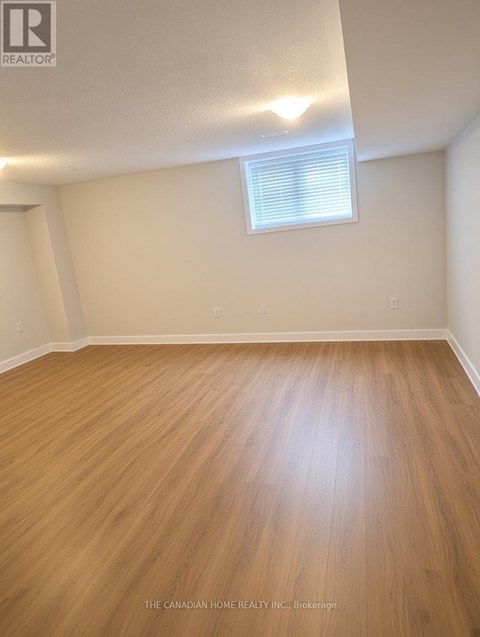 A room with wooden flooring and a window with blinds.
