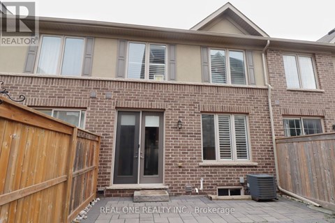 A house with a brown fence and a brick wall.