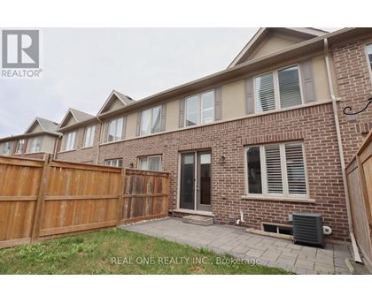A brick house with a wooden fence and a small patio.