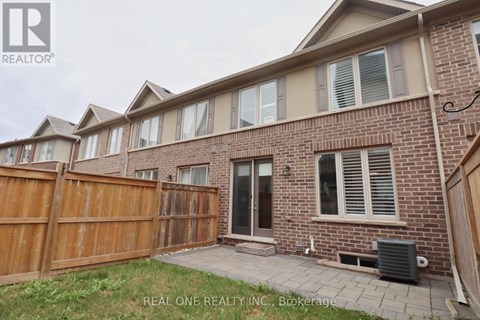 A brick house with a wooden fence and a small patio.