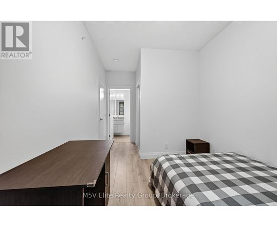 A bedroom with a bed, a table, and a chair.