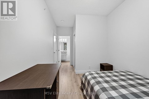 A bedroom with a bed, a table, and a chair.