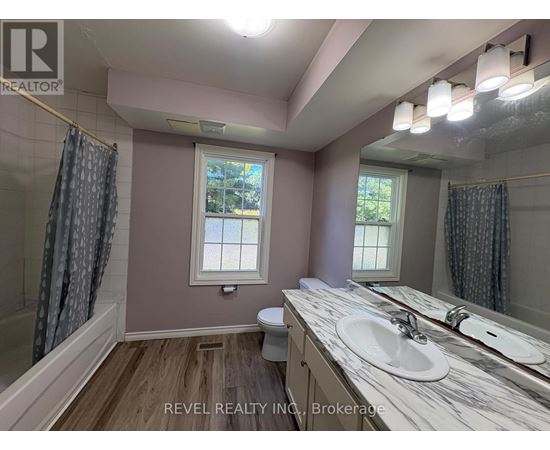 A bathroom with a marble countertop and a window.