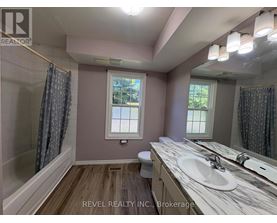 A bathroom with a marble countertop and a window with a view of trees.