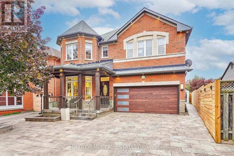 A red brick house with a garage door and a driveway.
