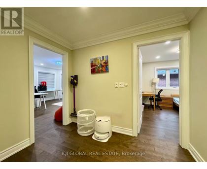 A brokerage office with a vacant room and a painting on the wall.