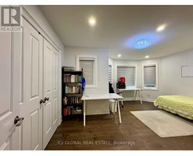 A bedroom with a bed, desk, and bookshelf.
