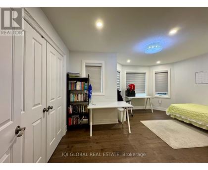 A bedroom with a bed, desk, and bookshelf.