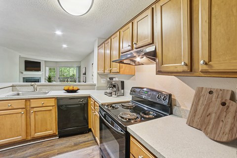 A kitchen with wooden cabinets and a black stove top oven.