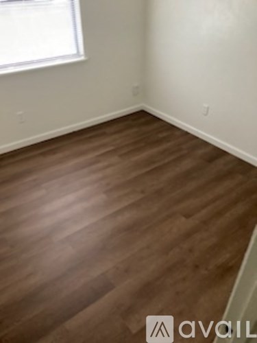 A room with wooden flooring and a window.