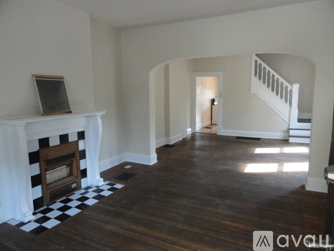 A living room with a fireplace and a checkered floor.