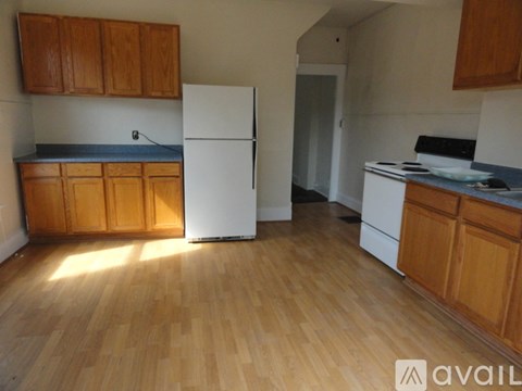 A kitchen with wooden cabinets and a white fridge.
