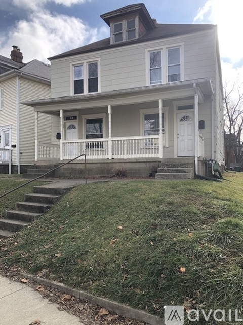 A two-story house with a front porch and a white door.