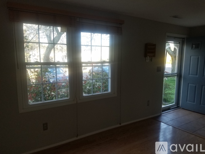 A room with a large window and a door leading outside.